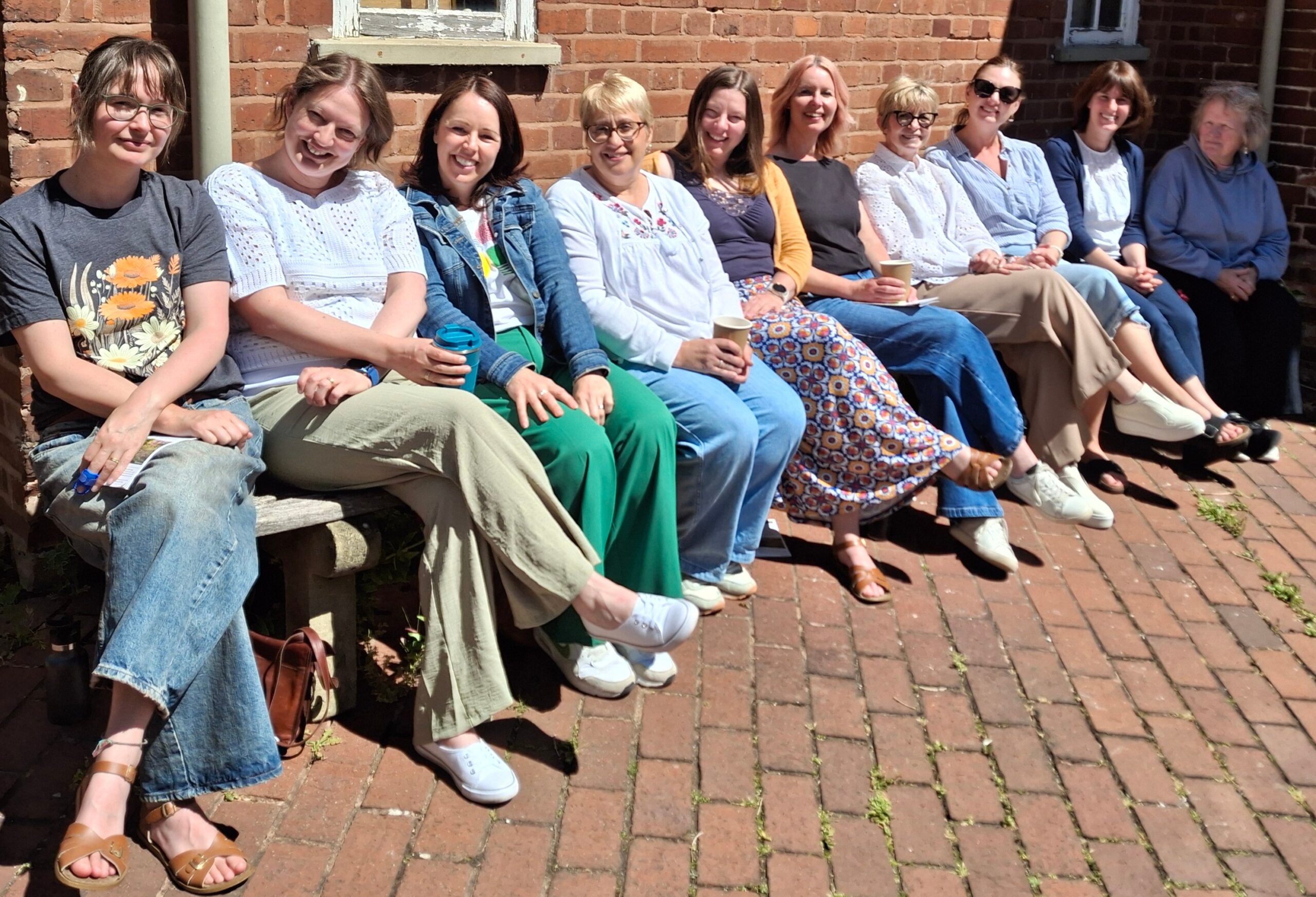 Soundswell team of speech & language therapists sitting in sunshine during CPD Day